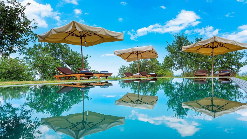 Elegant Sicilian villa with rustic stone walls, private infinity pool, and lush vineyard backdrop at boutique hotel near Mount Etna