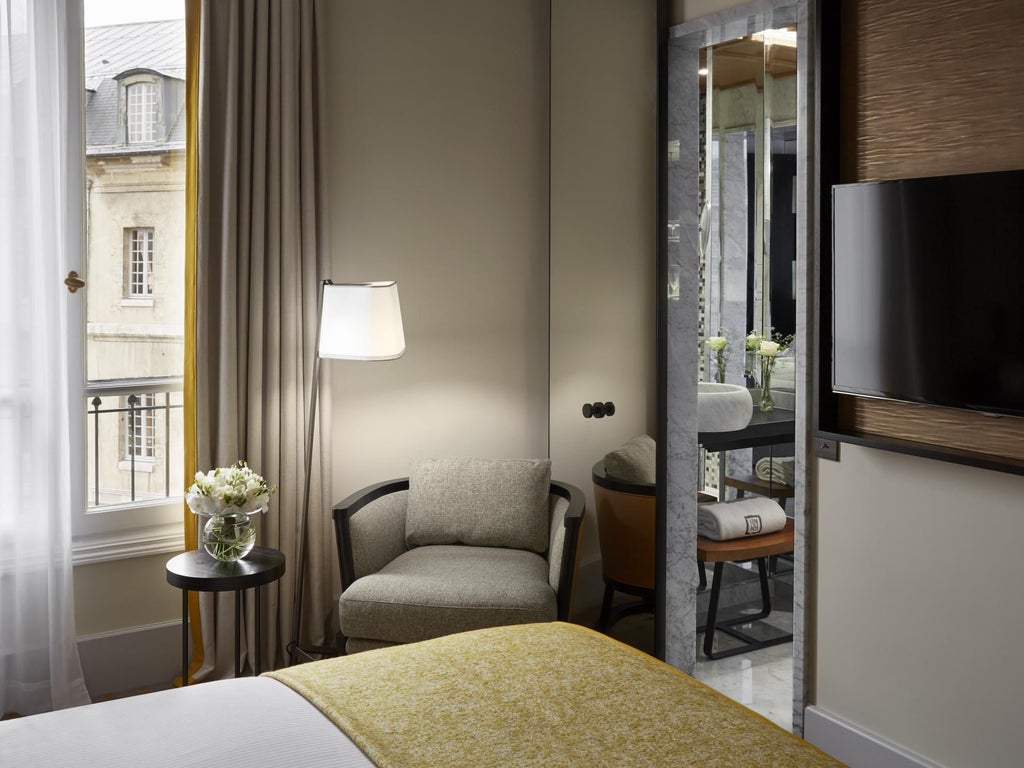 Elegant Parisian hotel room with plush white bedding, sophisticated neutral color palette, and chic contemporary design elements at Hotel Montalembert