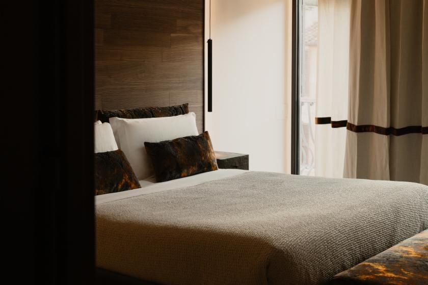 Elegant Italian hotel room near Piazza di Spagna, featuring luxurious white linens, marble details, and soft neutral tones with contemporary design