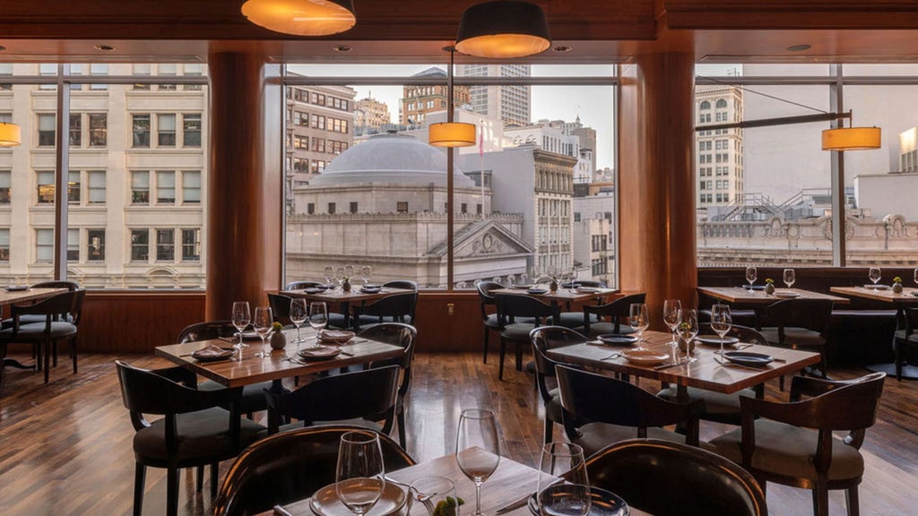 Luxurious exterior of scenset Hotel San Francisco, featuring modern glass facade, sleek architectural lines, and elegant urban skyline backdrop at twilight