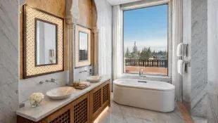 Expansive Moroccan royal suite with private infinity pool, ornate architectural details, traditional zellige tiles, and panoramic desert landscape view