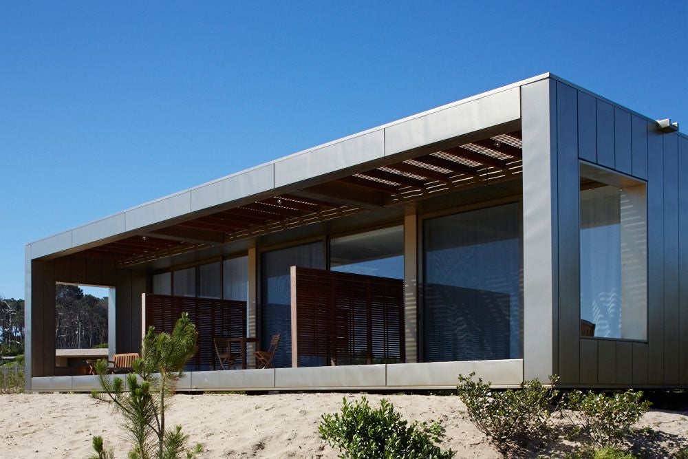 Modern minimalist bungalow at Bahia Vik resort, José Ignacio, Uruguay, with clean lines, wood accents, and panoramic windows overlooking coastal landscape