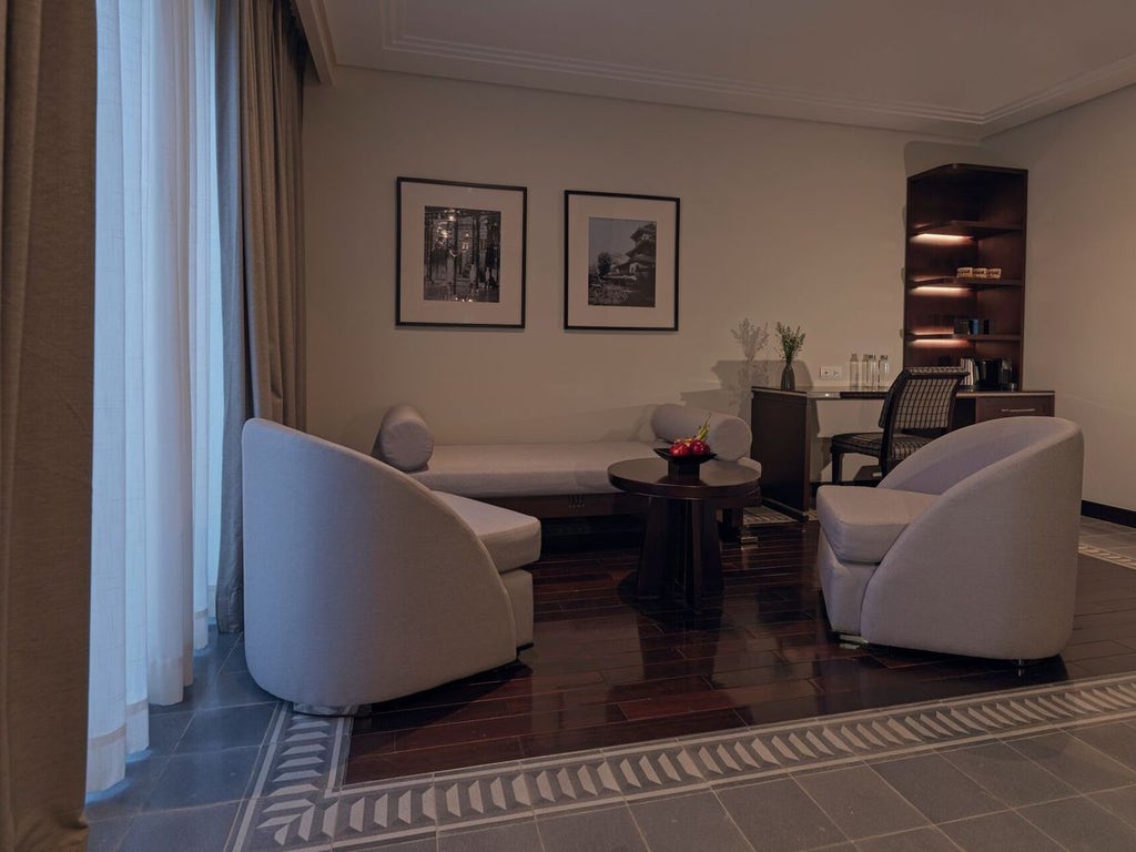 Elegant Deluxe Room at Azerai La Residence with colonial-inspired decor, wooden floors, white linens, and soft natural lighting in Hue, Vietnam