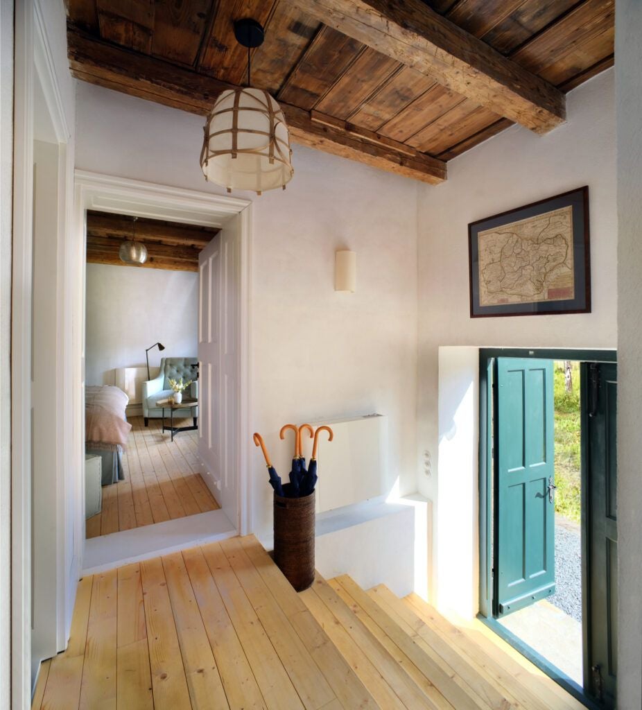 Elegant Transylvanian stone villa bedroom with traditional wooden furniture, plush textiles, and rustic architectural details showcasing historic Romanian hospitality