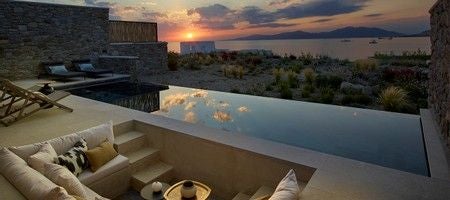 Luxurious one-bedroom villa in Mykonos with private heated pool, overlooking azure Aegean Sea, featuring elegant white architecture and contemporary design