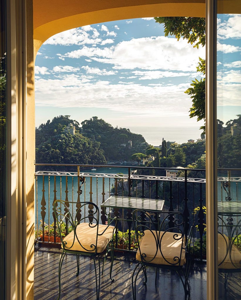 Luxury cliffside hotel with cream-colored facade and infinity pool overlooking the Amalfi Coast's turquoise Mediterranean waters