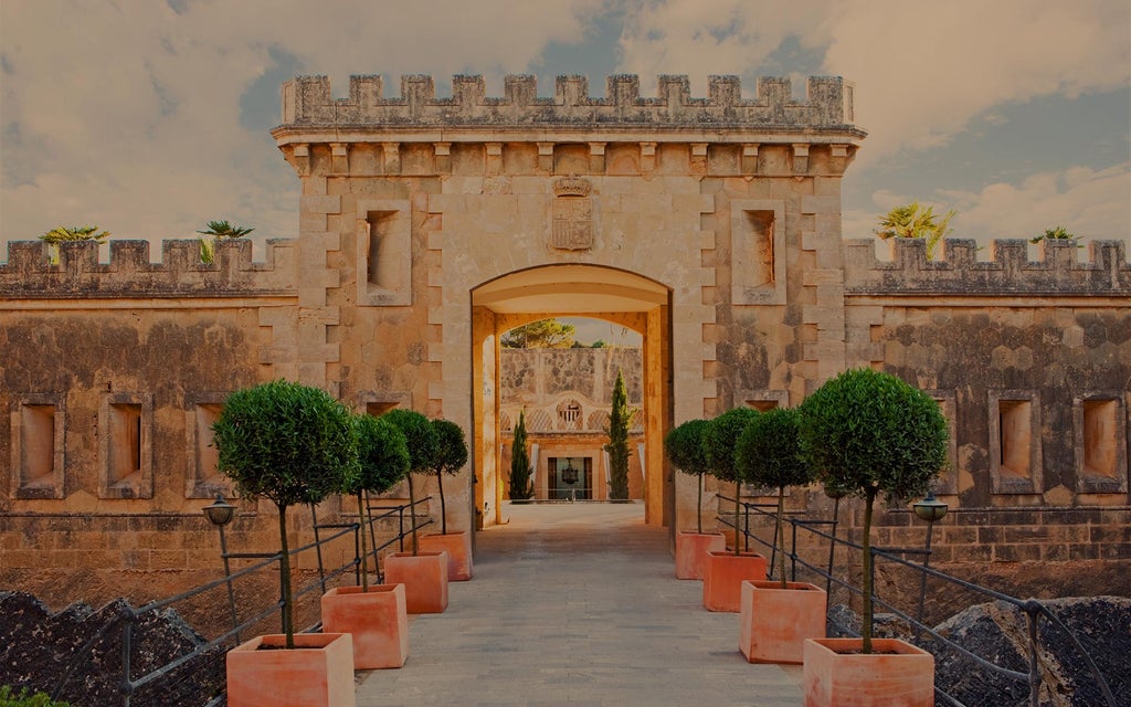 Luxurious fortress-turned-hotel Cap Rocat perched on Mallorca's cliffs, featuring stone walls and panoramic Mediterranean views