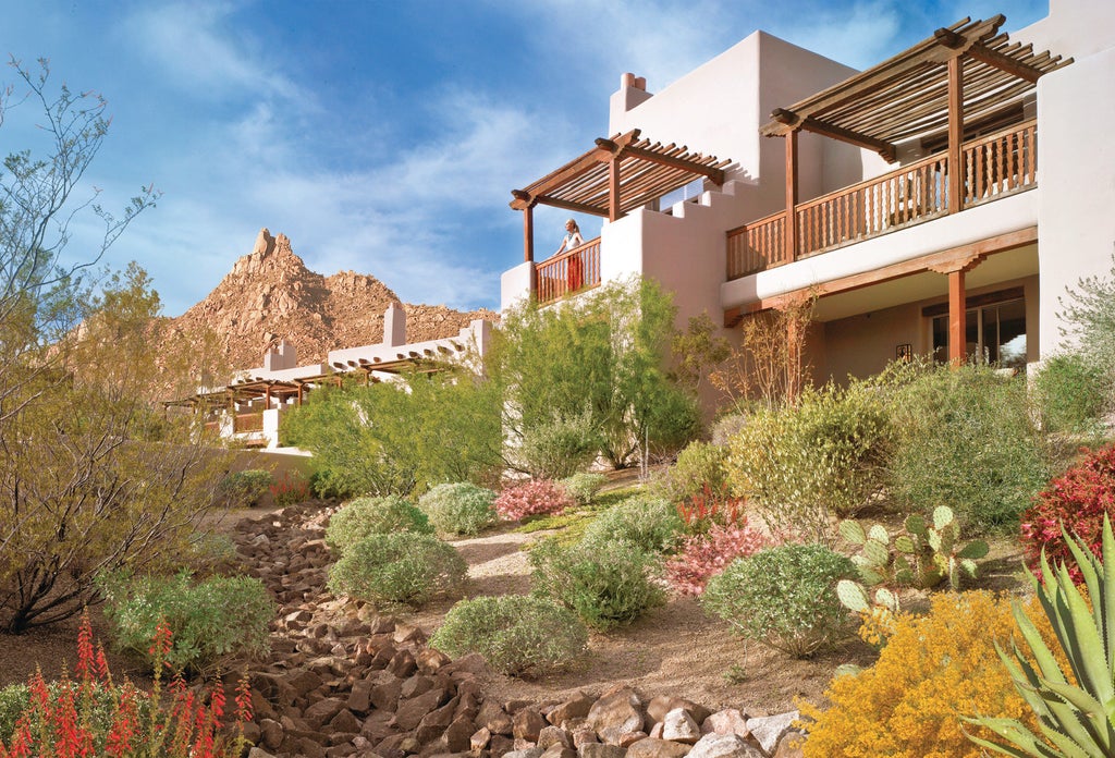 Desert-inspired adobe architecture of Four Seasons Resort rising from Sonoran landscape, with luxury pool and mountain vista backdrop