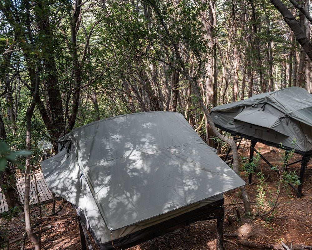 Luxurious premium camping room at Hotel Las Torres Patagonia, featuring elegant bedding, mountain-inspired decor, and panoramic wilderness views of Chilean landscapes