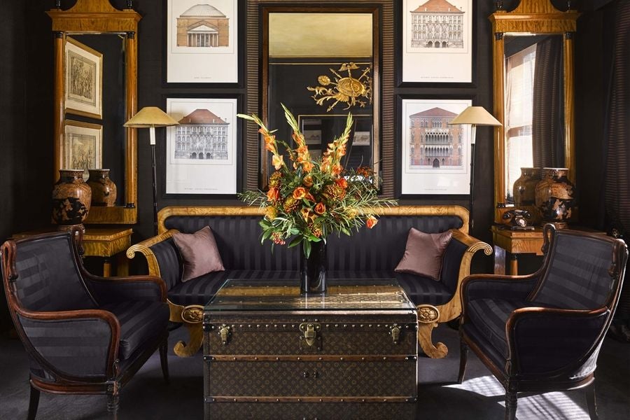 Elegant townhouse suite at scenset hotel, featuring plush king-sized bed, sophisticated dark wood furnishings, and luxurious textured gray headboard