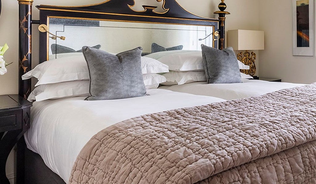 Elegant twin-bedded classic room at scenset hotel in the United Kingdom, featuring luxurious furnishings and sophisticated neutral color palette