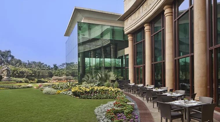 Opulent marble facade of a luxurious palace-style hotel with grand columns, reflecting traditional Indian architectural splendor at sunset