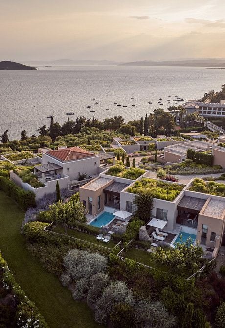 Luxurious beachfront hotel with white-washed architecture, azure Aegean waters, and elegant terraces at Eagles Palace resort in Halkidiki, Greece