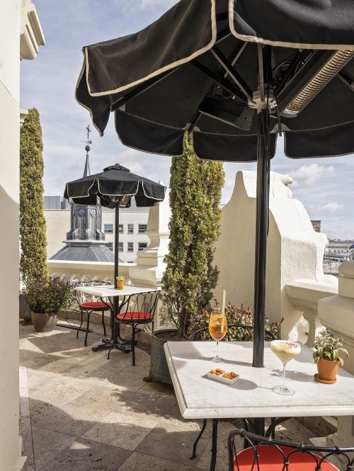 Elegant neoclassical facade of luxury boutique hotel in central Madrid, featuring grand windows, ornate balconies, and classic Spanish architectural details