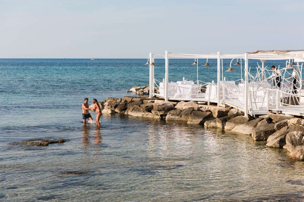 Luxurious coastal hotel overlooking azure Adriatic waters, featuring sleek modern architecture with minimalist pool and elegant Mediterranean landscape