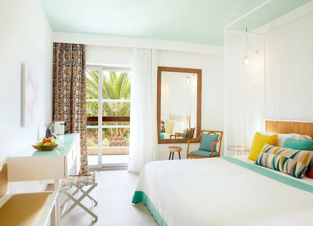 Luxurious deluxe double room at Eagles Palace hotel with panoramic Aegean Sea view, elegant white furnishings, and private balcony overlooking turquoise waters of Greece