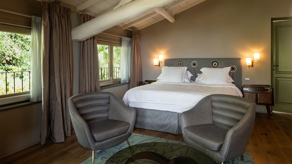 Elegant Tuscan-style boutique hotel room with soft neutral tones, minimalist wooden furniture, and panoramic countryside view through large windows