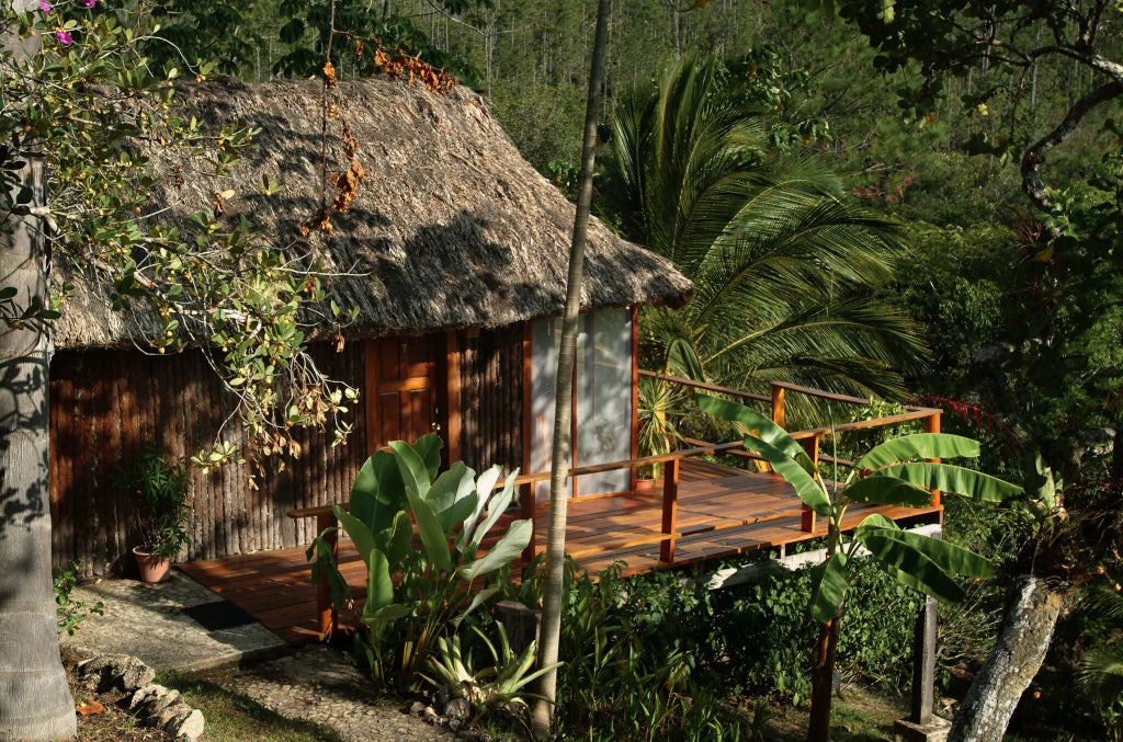 Luxurious wooden cabin interior with panoramic mountain view, warm earth tones, modern rustic decor, and expansive windows in Argentinian landscape