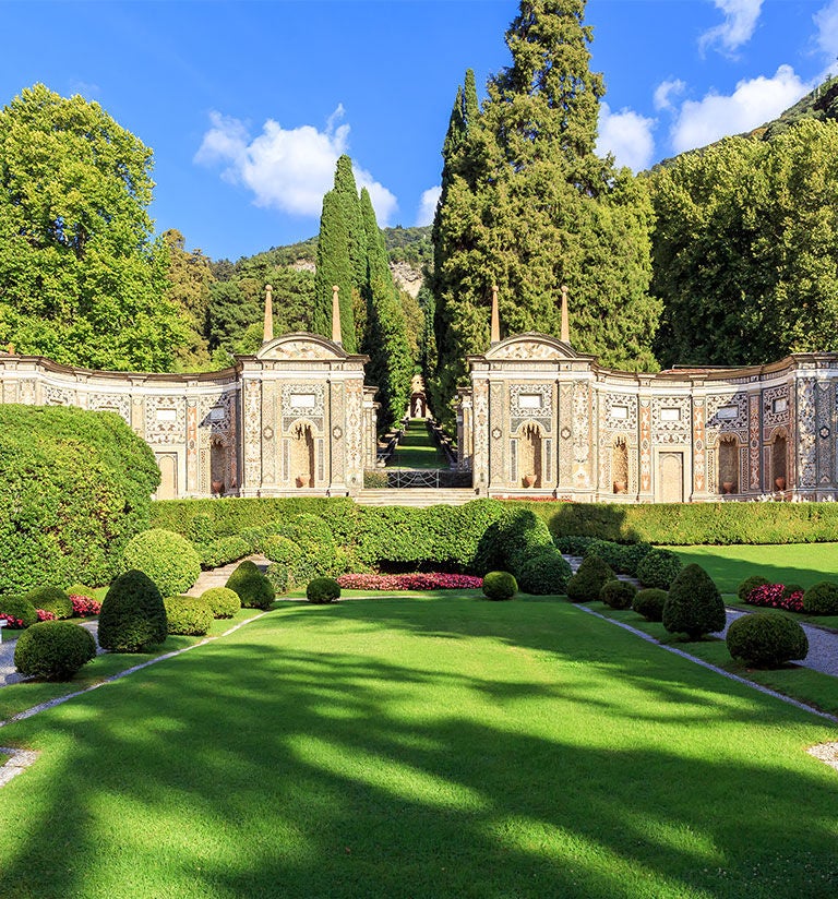 Grand Renaissance-style Villa d'Este hotel overlooking Lake Como, featuring manicured gardens, elegant terraces, and ornate fountains