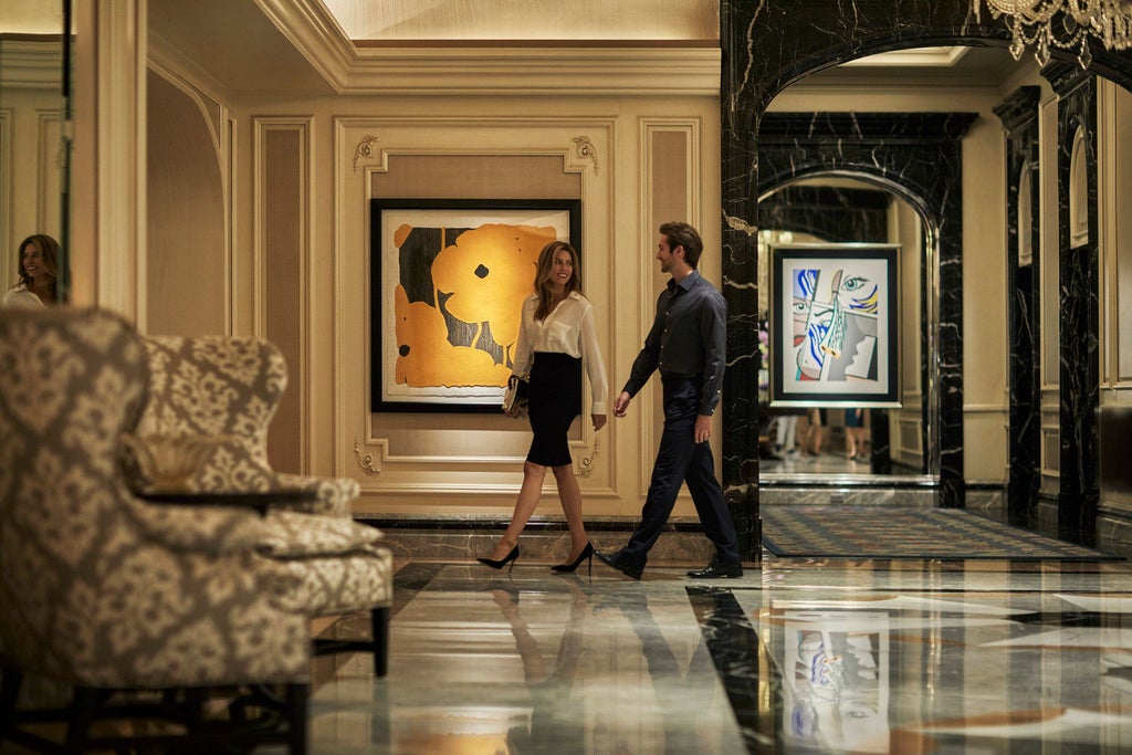 Opulent art deco-styled lobby of Four Seasons Chicago with crystal chandelier, marble floors, and elegant floral arrangements near sofas