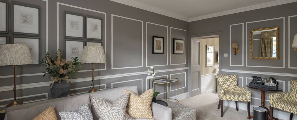 Elegant junior suite with Georgian-style decor, plush king bed, soft neutral tones, ornate furnishings, and panoramic view of historic architectural landscape in Bath, UK