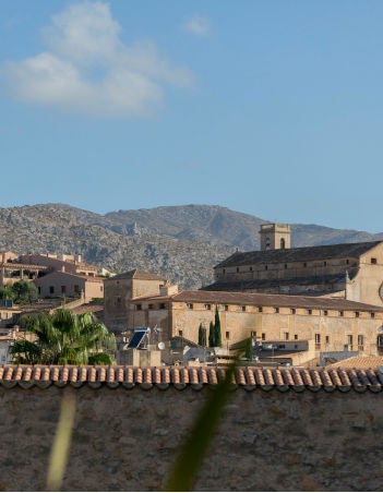 Stone-walled boutique hotel in rural Spain with arched doorways, rustic wooden beams, and a tranquil courtyard surrounded by olive trees