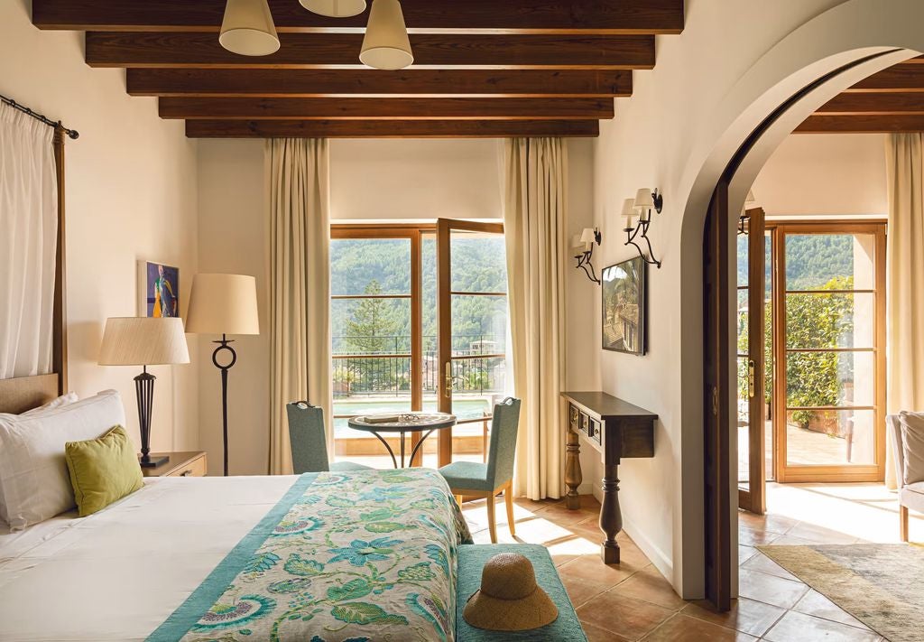 Sunlit exclusive suite with elegant antique furnishings, white canopy bed, private terrace and mountain views at La Residencia, Mallorca