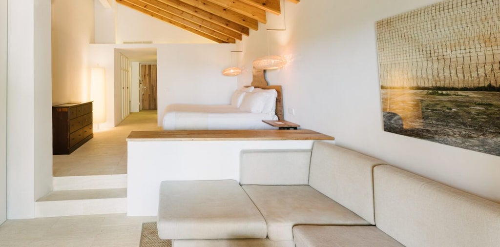 Elegant Mediterranean hotel room with minimalist white decor, large windows overlooking azure coastline, creating a serene and luxurious seaside retreat in Spanish landscape