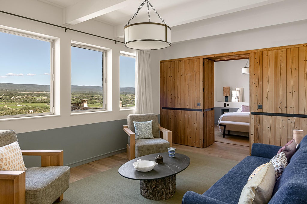 Elegant suite with exposed stone walls, beamed ceiling, canopy bed and Mont Ventoux mountain views through French windows