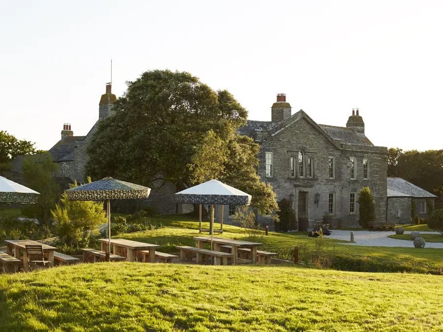 Rustic-chic countryside hotel nestled in lush Devon landscape, with stone exterior, manicured gardens, and elegant country house architecture