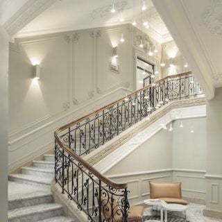 Elegant marble lobby of luxury hotel with modern chandeliers, sleek Nordic design, and plush seating in muted tones of cream and charcoal