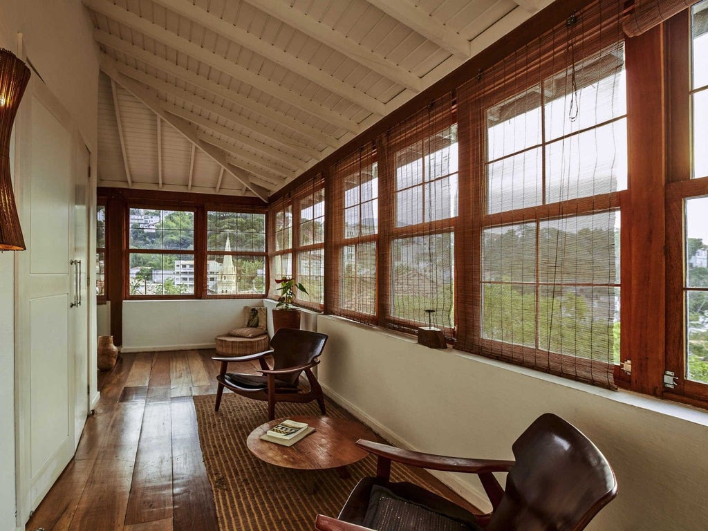 Luxurious Design Loft Suite at Santa Teresa Hotel RJ, featuring elegant modern decor, warm wood tones, and expansive city views of Brazil's vibrant landscape.