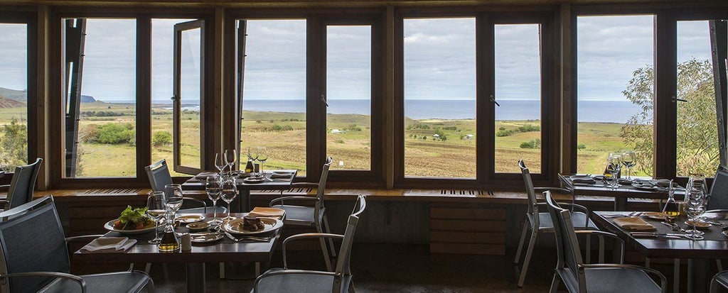 Luxurious eco-lodge nestled on Easter Island's rugged coastline, blending modern architecture with dramatic volcanic landscape and Pacific Ocean views