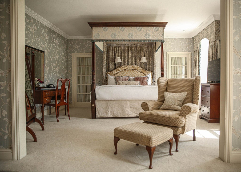 Elegant junior suite at Lucknam Park Hotel & Spa, featuring plush cream-colored furnishings, classic decor, and soft natural lighting in a refined UK countryside setting