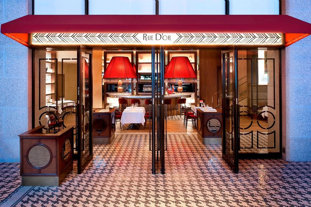 Opulent beaux-arts style hotel with ornate limestone facade, grand entrance with red awning and American flags in Washington DC