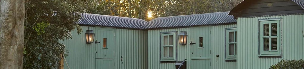 Rustic luxe forest cabin hotel room with exposed wooden beams, plush bedding, and warm ambient lighting nestled in scenic woodland setting