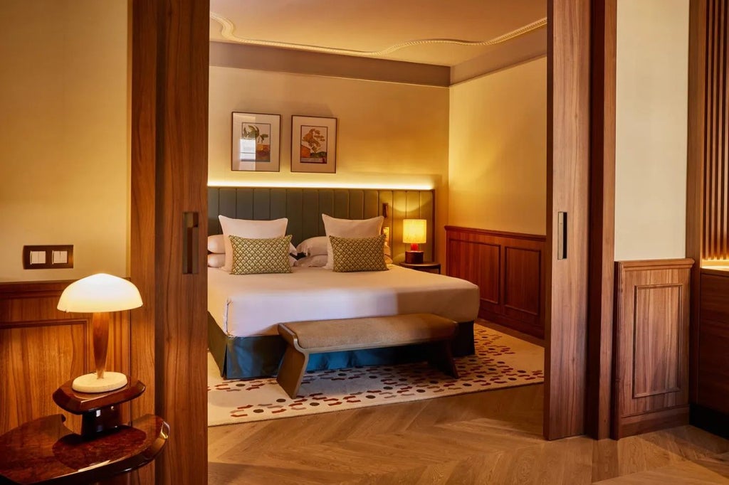 Elegant master suite in Spanish Grand Hotel Central with plush king bed, marble bathroom, city view, rich wood furnishings, and contemporary design elements