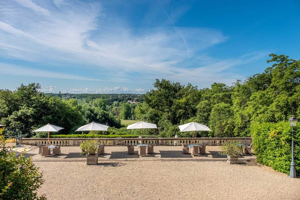 Elegant French chateau hotel with ornate architecture, surrounded by manicured gardens and reflecting pools at golden hour