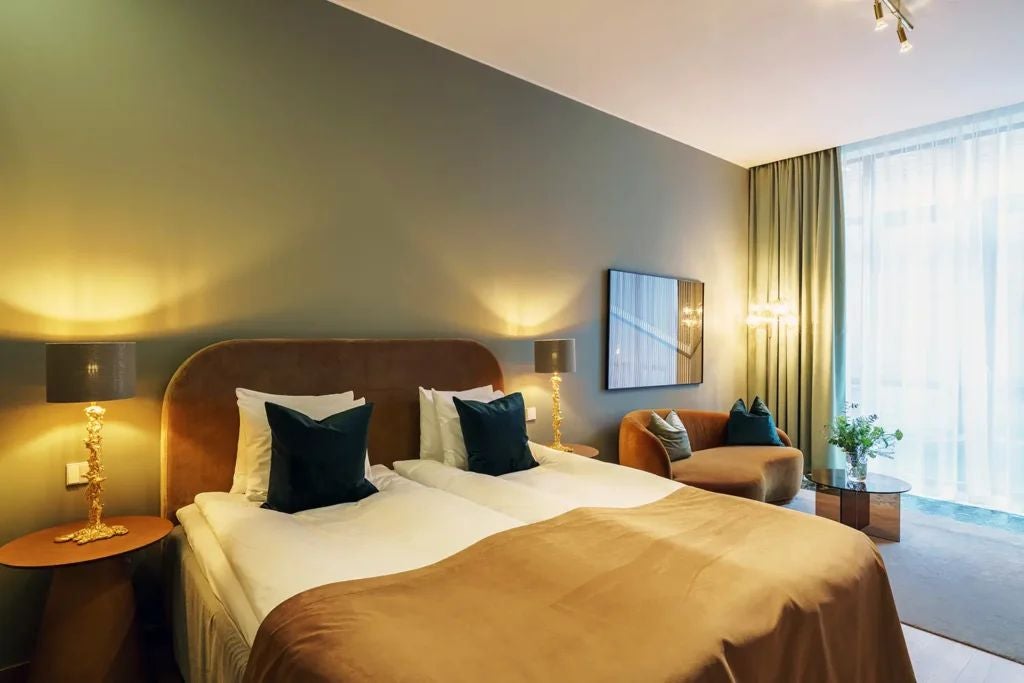 Elegant, spacious hotel room with modern Swedish design, featuring plush bedding, large windows, and sophisticated neutral color palette in Berns Hotel