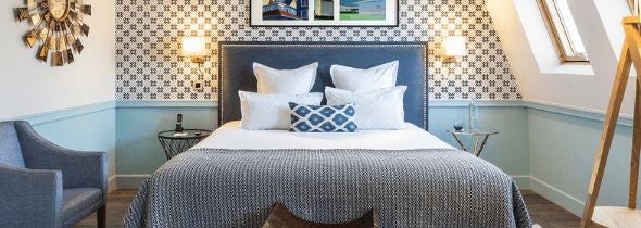 Elegant junior suite with plush white bedding, soft neutral tones, modern minimalist decor, and chic French-inspired design elements in Paris hotel room