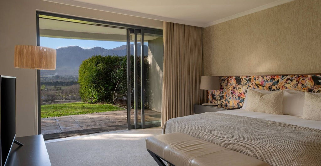 Elegant CAP Classique Suite at Mont Rochelle, featuring plush king bed, vineyard-view windows, and sophisticated contemporary South African design