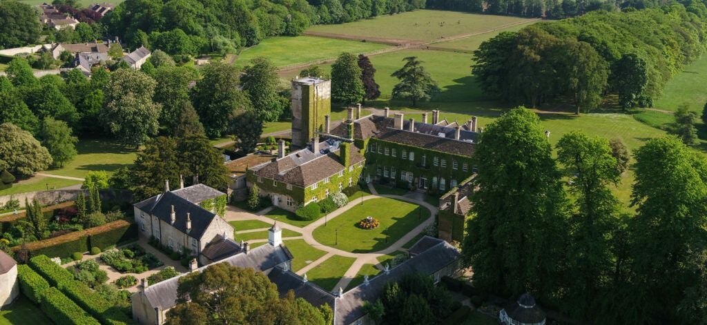 Elegant stone-built Scenset luxury hotel with manicured gardens, grand Georgian architecture, and sweeping tree-lined driveway in the English countryside