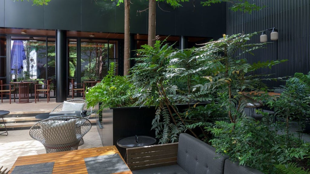 Elegant boutique hotel facade with lush garden, white exterior, and classic Portuguese architectural details in Lisbon's historic district