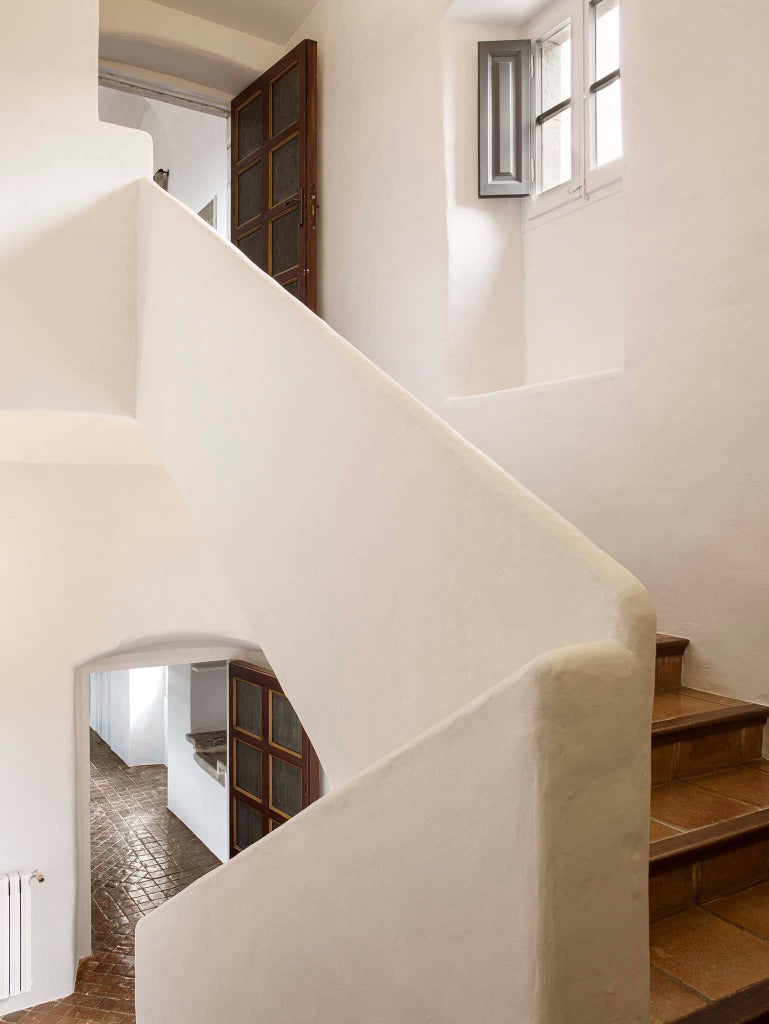 Elegant stone villa with ivy-covered walls, traditional shutters, and manicured gardens at luxury Hotel Mas de Torrent in Costa Brava, Spain