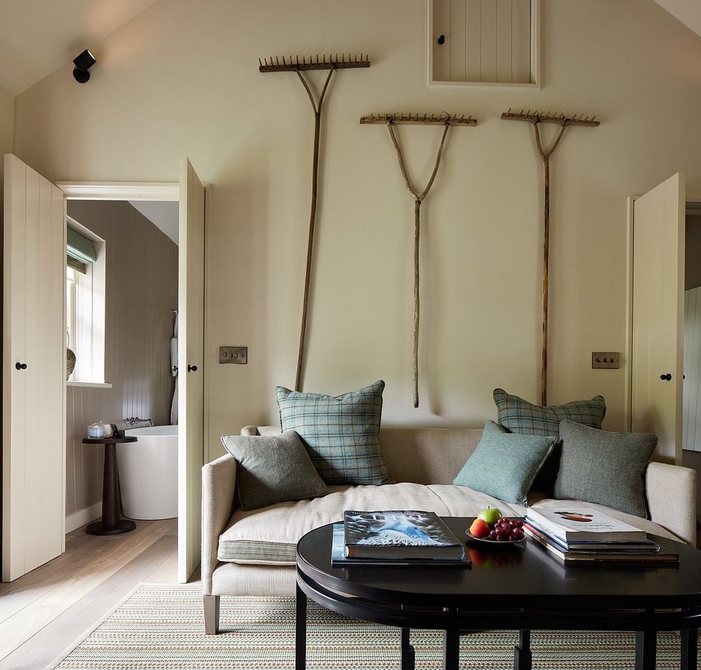 Elegant luxury suite with soft neutral tones, plush upholstered headboard, crisp white linens, and refined wooden furniture at Grove of Narberth boutique hotel