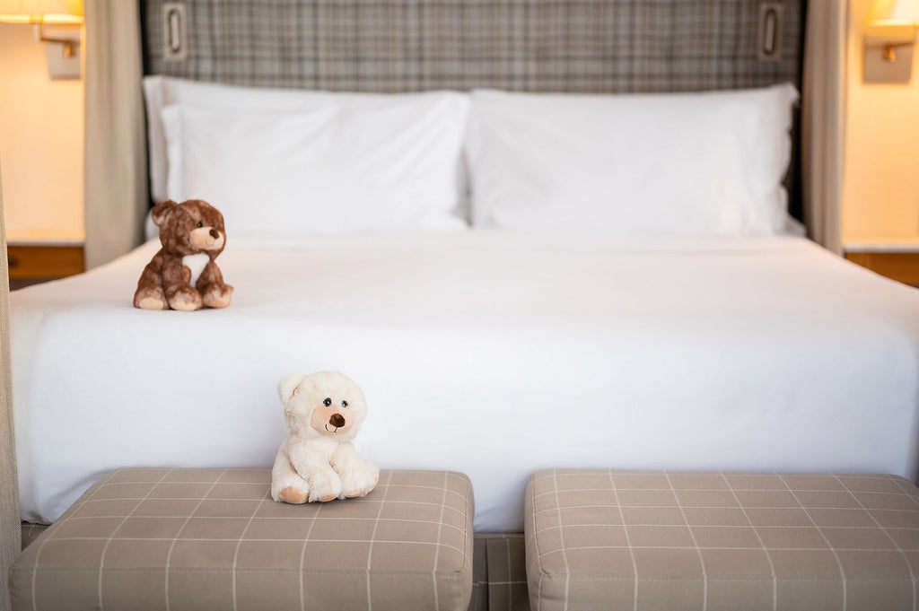 Elegant URSO Suite Familiar with plush king bed, contemporary Spanish design, warm neutral tones, and expansive city view from luxury Madrid boutique hotel