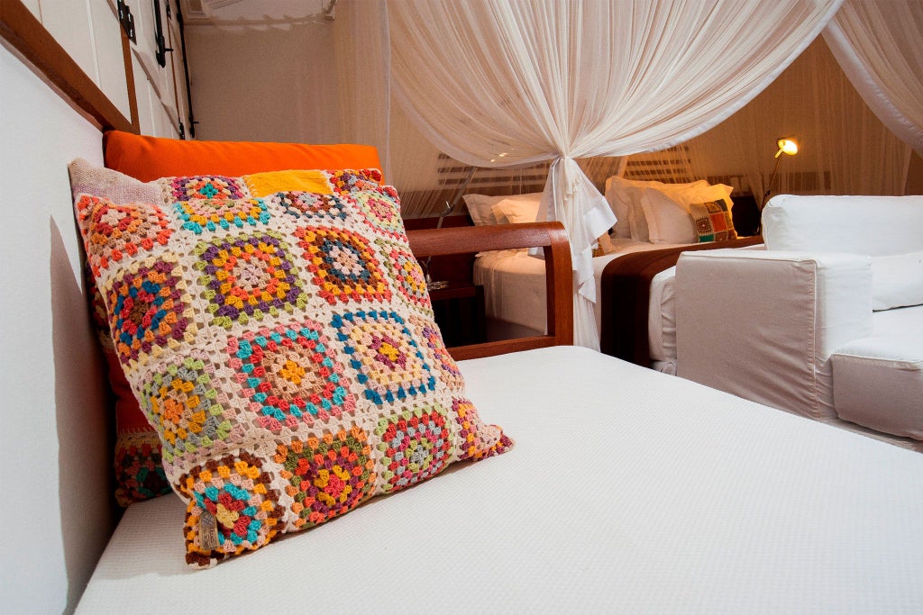 Luxurious brown suite with elegant wooden furniture, plush bedding, and warm accent lighting in Casa Turquesa boutique hotel, Brazil