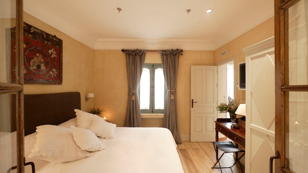 Elegant Spanish boutique hotel facade featuring wrought iron balconies, traditional white walls and historic wooden doors in Seville