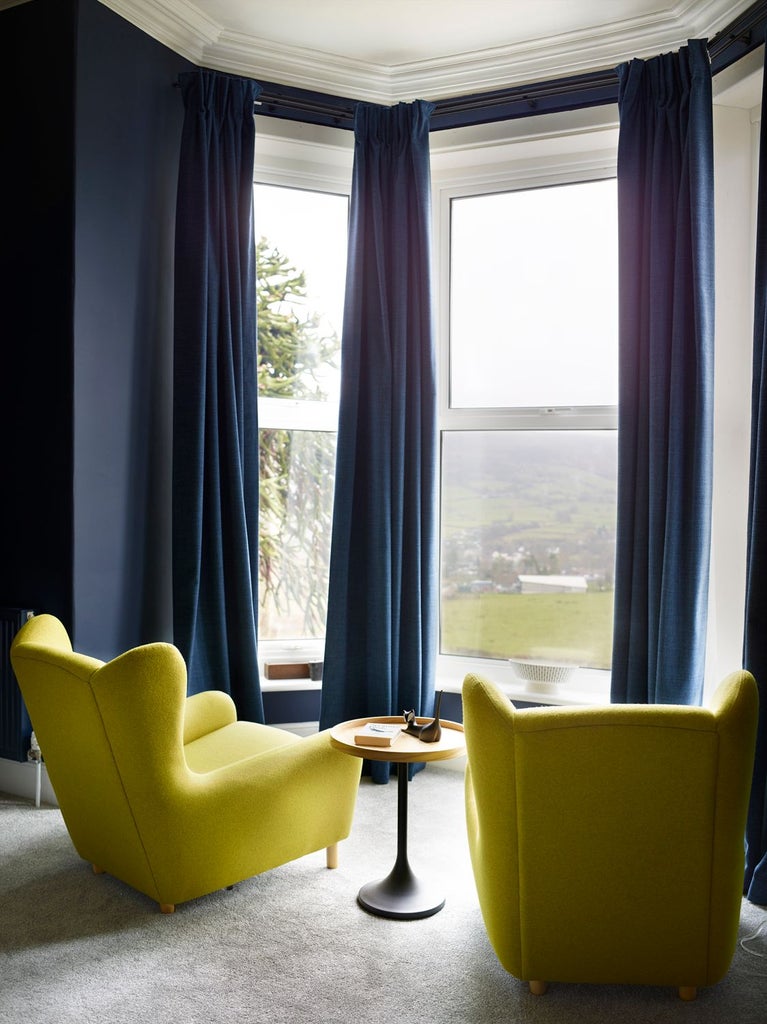 Elegant superior hotel room with plush white bedding, modern minimalist decor, and large windows offering soft natural light in a UK boutique hotel