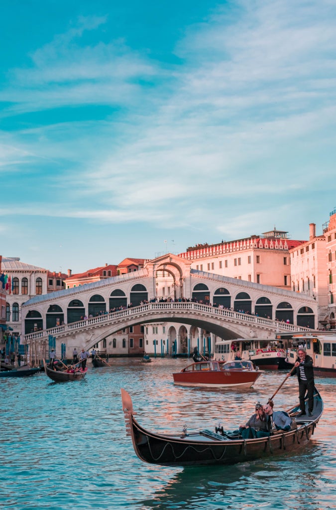 Grand Venetian canals, iconic gondolas under ornate bridges, Renaissance architecture and St. Mark's Basilica reflecting in turquoise waters